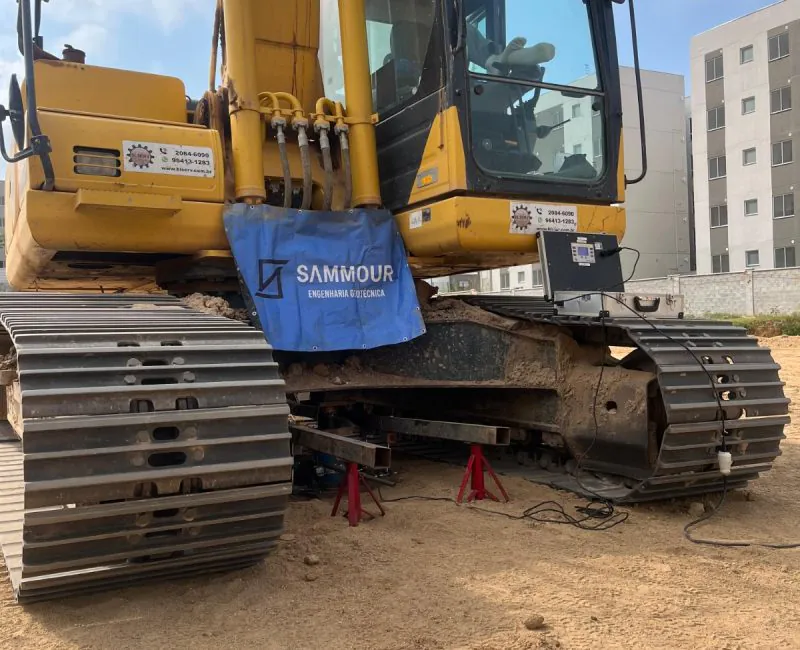 Detalhe da cabine de escavadeira amarela com equipamento de ensaio de placa Sammour