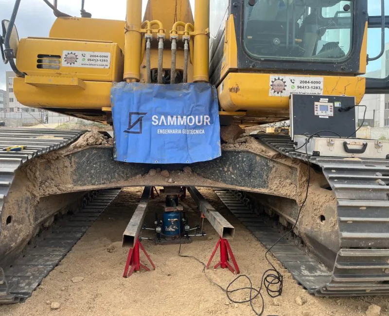 Detalhe do equipamento de ensaio de placa com cilindro hidráulico sob escavadeira Sammour