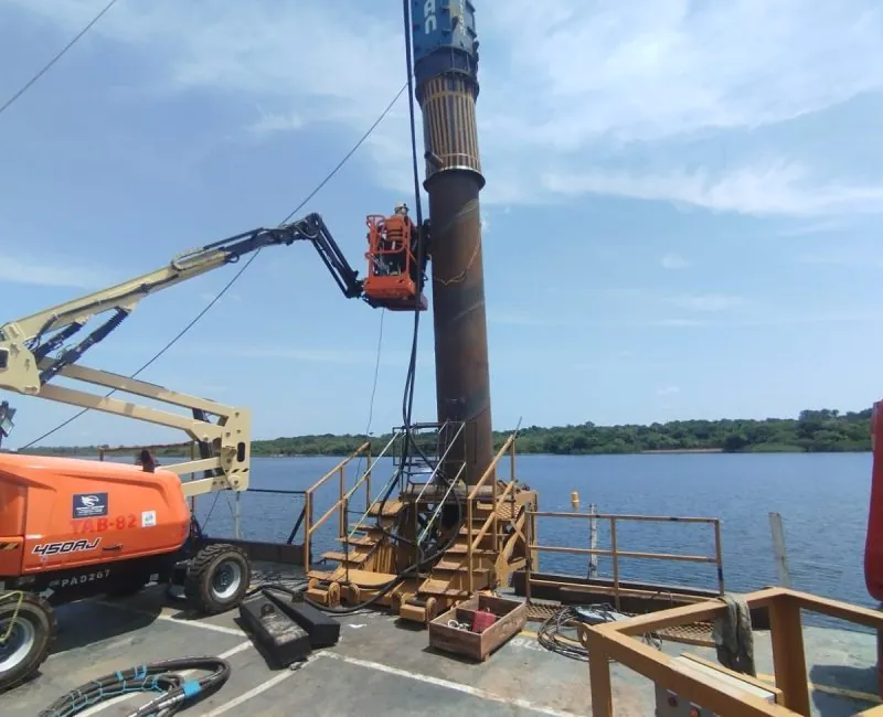 Técnico em plataforma elevatória instrumentando estaca tubular para ensaio PIT Pile Integrity Test