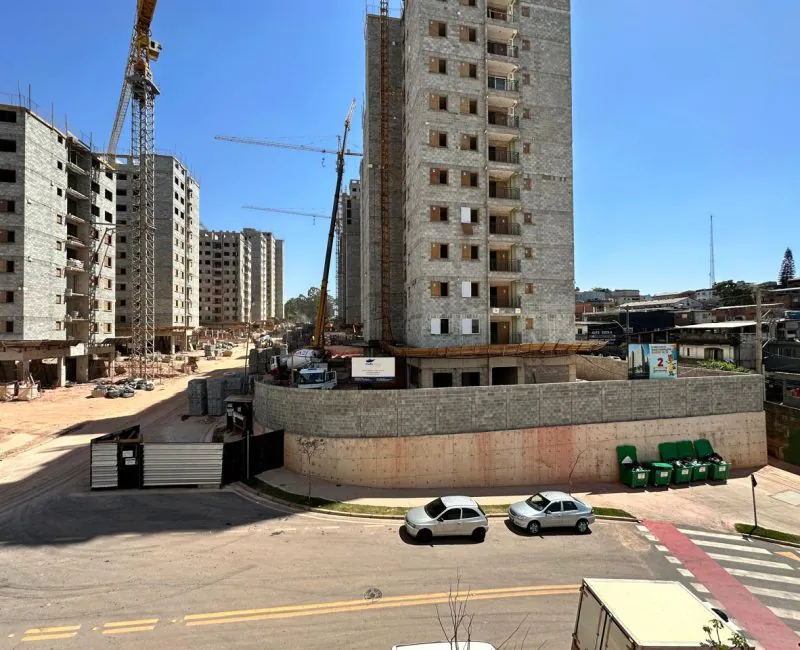 Edifício em construção com contenção periférica e guindaste