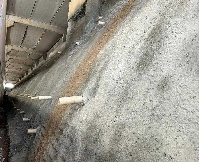Parede de contenção em concreto com drenos instalados para fundações e contenções
